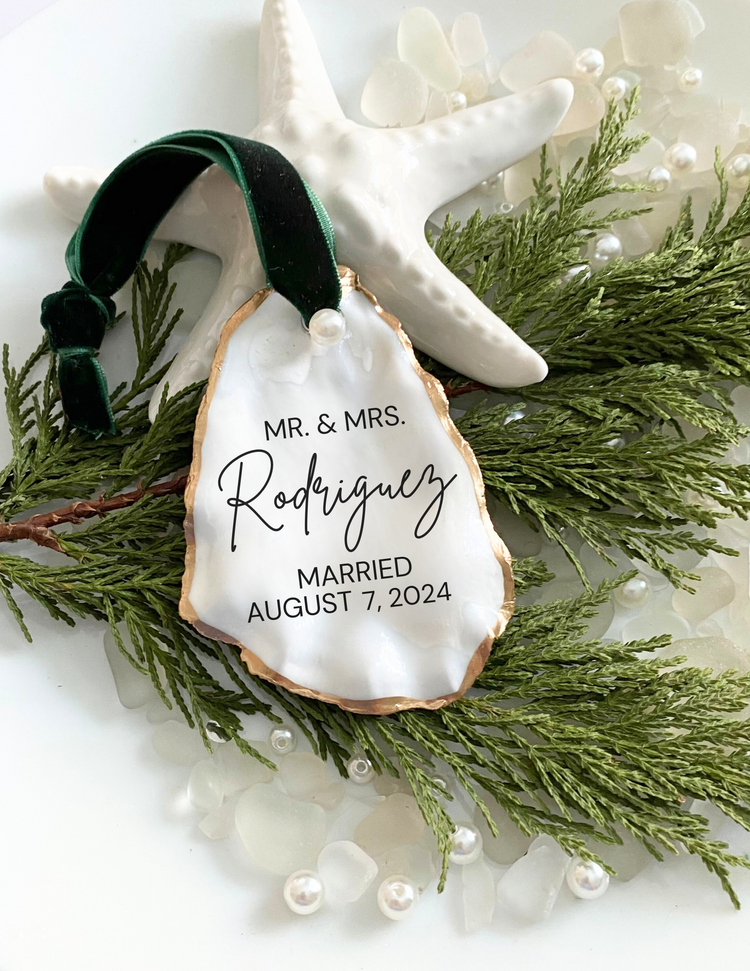 All natural handmade personalized oyster shell ornament with pearl paint and gold gild paint on edges adorned with ivory or rose gold satin ribbon and a cultured pearl