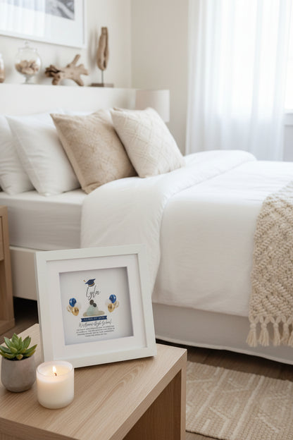 Framed graduation-themed sea glass art in a coastal bedroom.