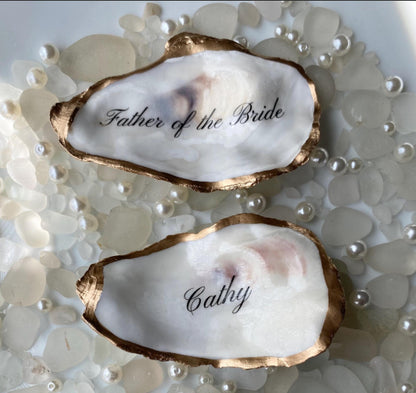 Two oyster shells with 'Father of the Bride' and 'Cathy' engraved on a pearl background