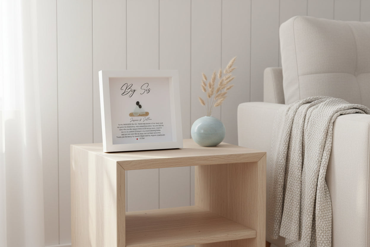 Personalized Big Sister gift with sea glass and pebble art, displayed in a white frame with a written message and a small sea glass figure.