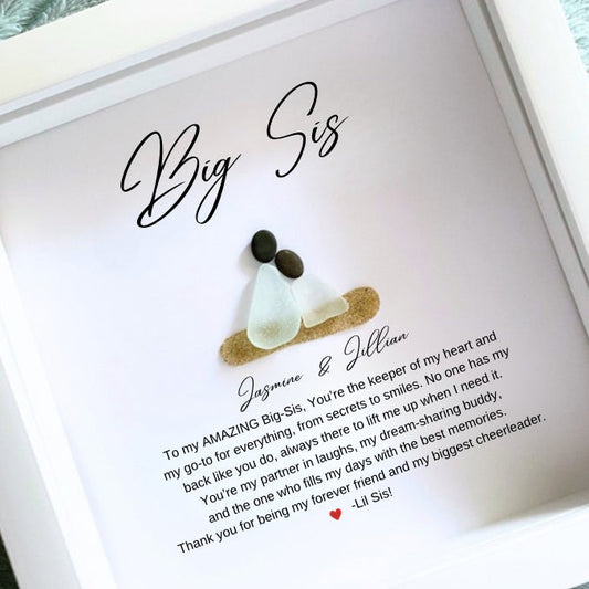 Personalized Big Sister gift with sea glass and pebble art, displayed in a white frame with a written message and a small sea glass figure.