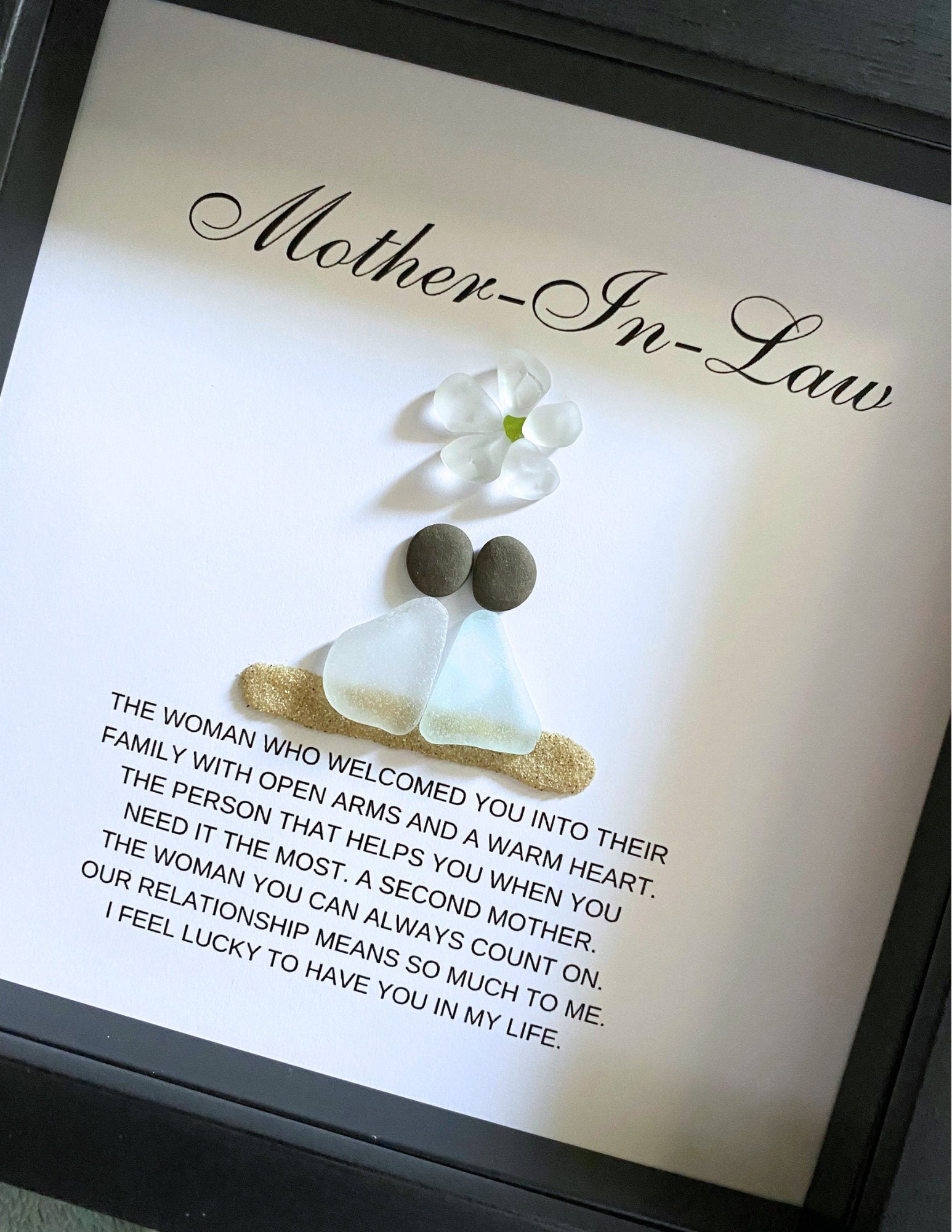 Personalized framed sea glass art for mother-in-law featuring two figures, a small glass flower, names, and custom message in a 9x9 shadow box.
