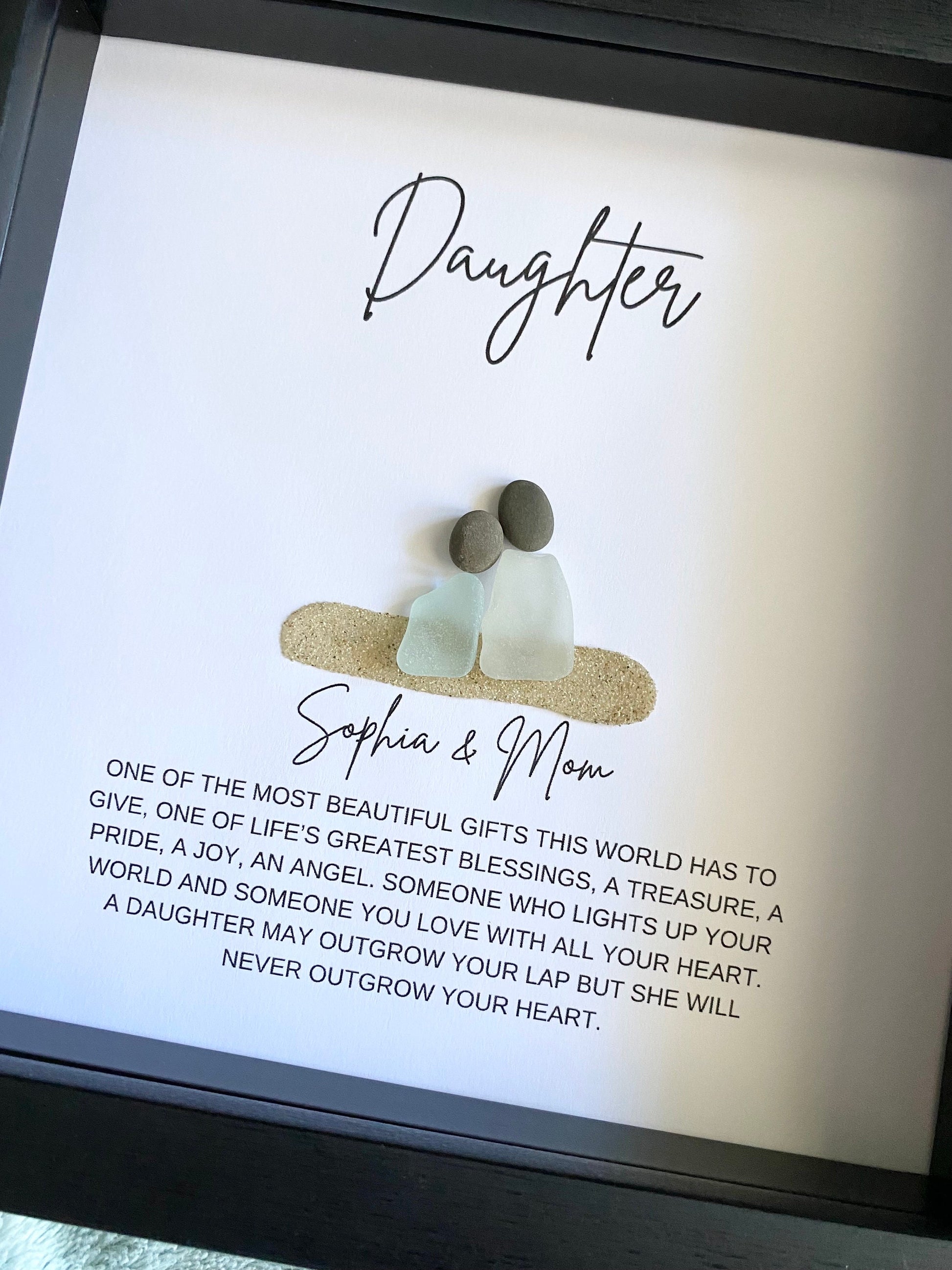 Framed artwork with 'Daughter' and 'Sophia & Mom' text, featuring two small figures and a quote.