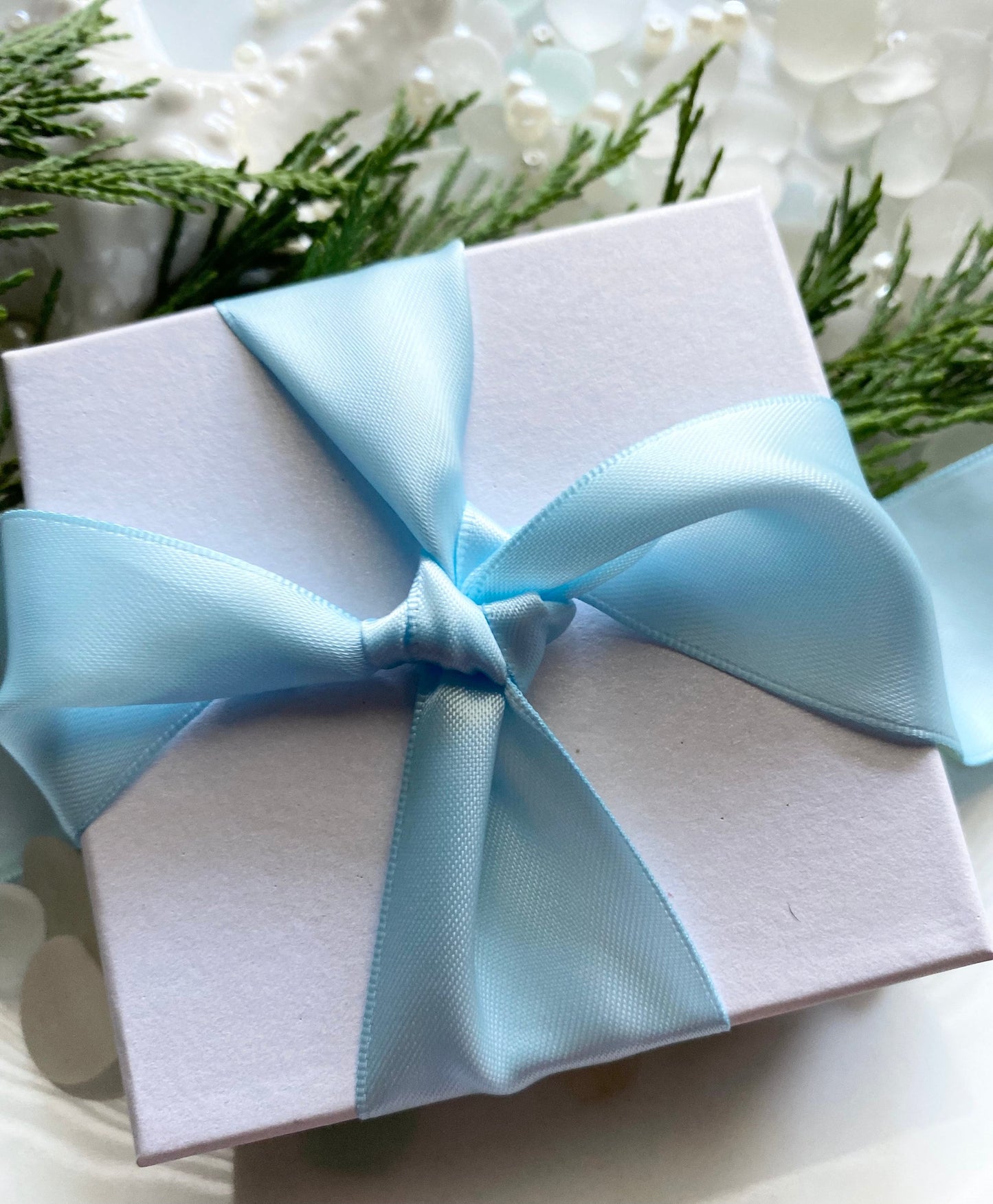 A white gift box with blue satin ribbon
