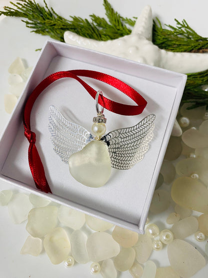 A handcrafted sea glass angel Christmas ornament with a red ribbon, displayed in a white jewelry box