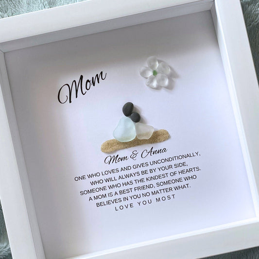 Mom and Daughter Sea glass figures with pebble heads sitting on sand with their names below and a little quote. On top it says "Mom" with a glass flower.