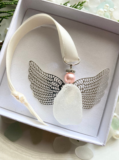 Sea glass angel ornament with a whitish sea glass body, silver metal wings, an ivory satin ribbon hanger, and a pink pearl-like head in a white gift box