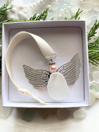 Sea glass angel ornament with a whitish sea glass body, silver metal wings, an ivory satin ribbon hanger, and a pink pearl-like head in a white gift box