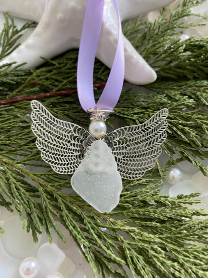 Sea glass angel ornament with a whitish sea glass body, silver metal wings, a lavender satin ribbon hanger, and a cream pearl-like head