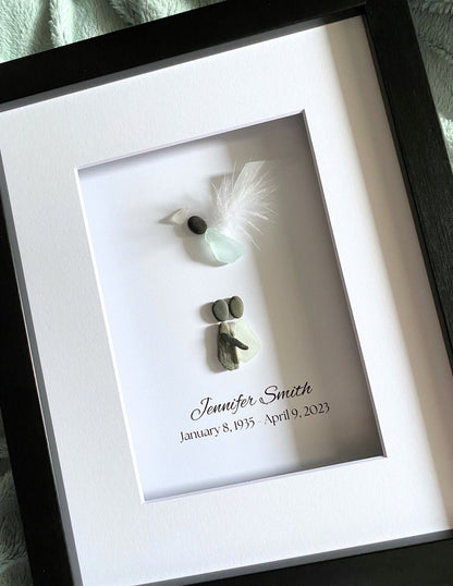 Framed memorial with a name and dates, featuring small decorative elements.