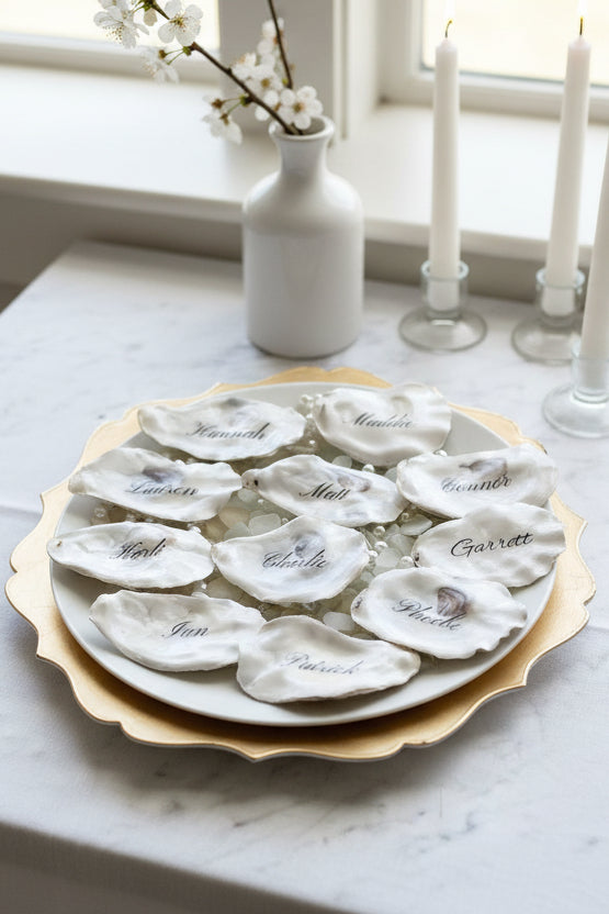 Oyster shell place cards with names engraved on a decorative plate