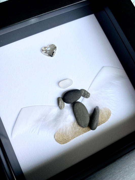 A personalized dog memorial gift featuring a white sea glass and pebble art piece with a shadowbox frame.