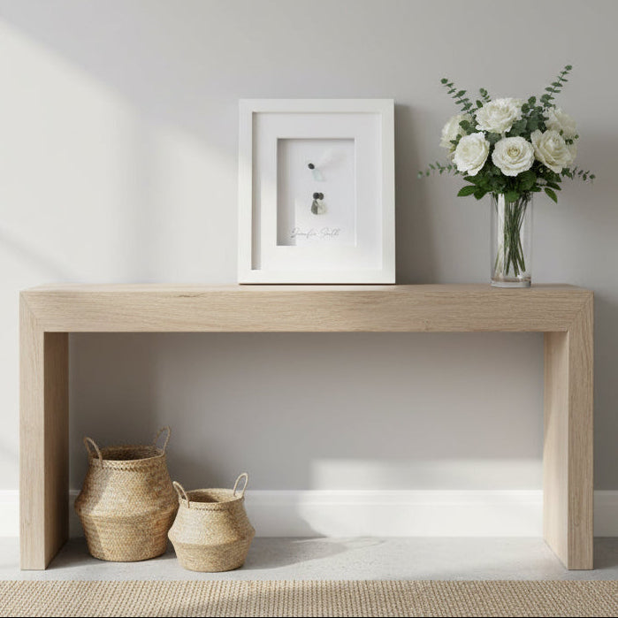 Wooden console table with decorative items against a plain wall